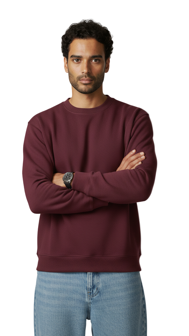 Man wearing a maroon sweatshirt and light blue jeans against a plain background