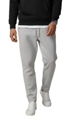 Person wearing gray sweatpants and a black top on a white background