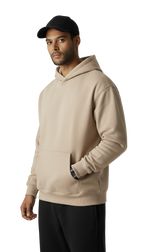 Man wearing a beige hoodie and black cap on a white background