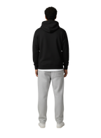 Person wearing a black hoodie and gray sweatpants on a white background