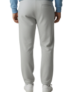 Person wearing a light blue sweater and gray pants on a plain background