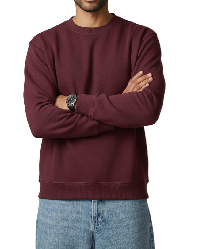 Man wearing a maroon sweatshirt and light blue jeans against a plain background