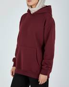 Maroon hoodie worn by a person on a white background