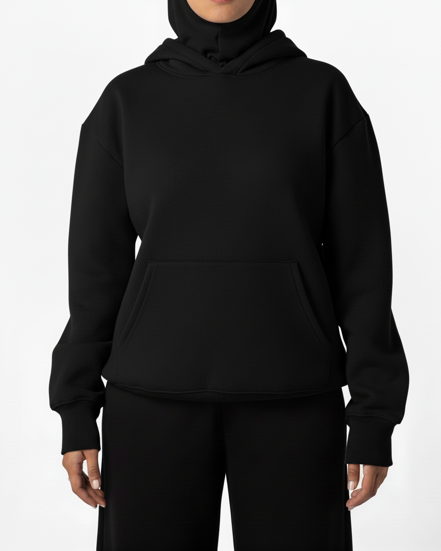 Person wearing a black hoodie and pants on a white background