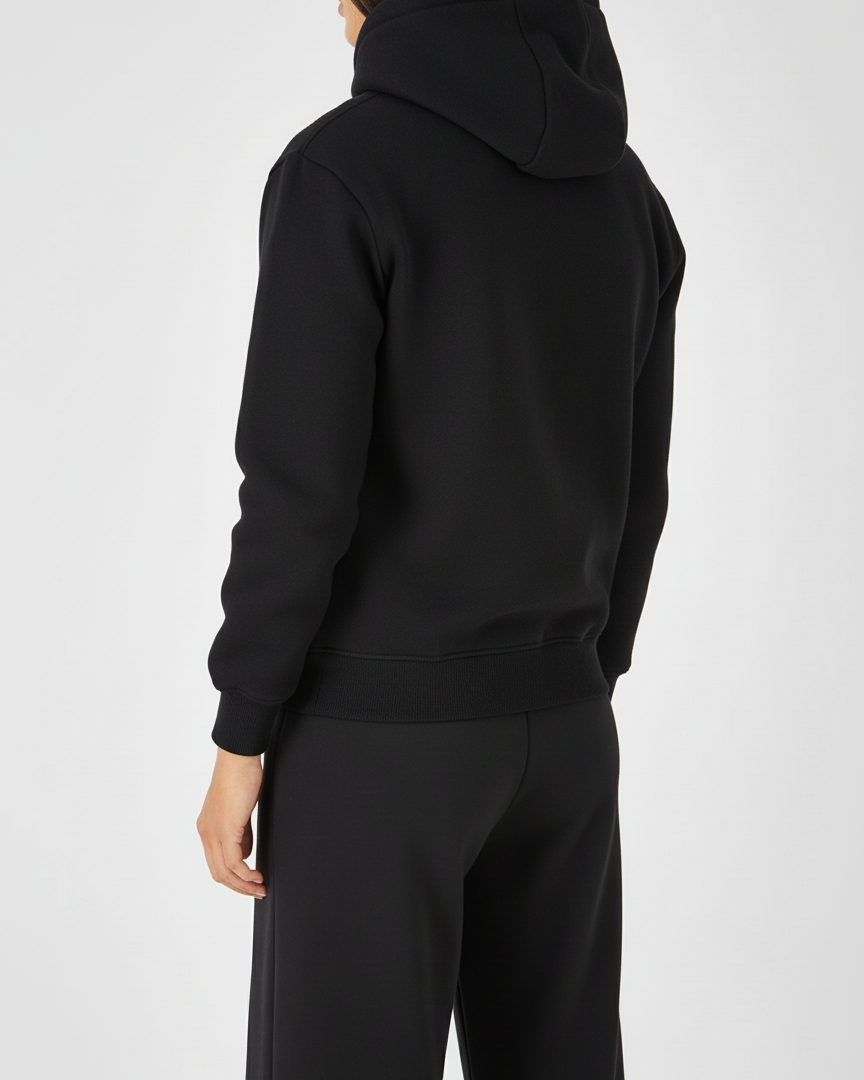 Person wearing a black hoodie and pants on a white background