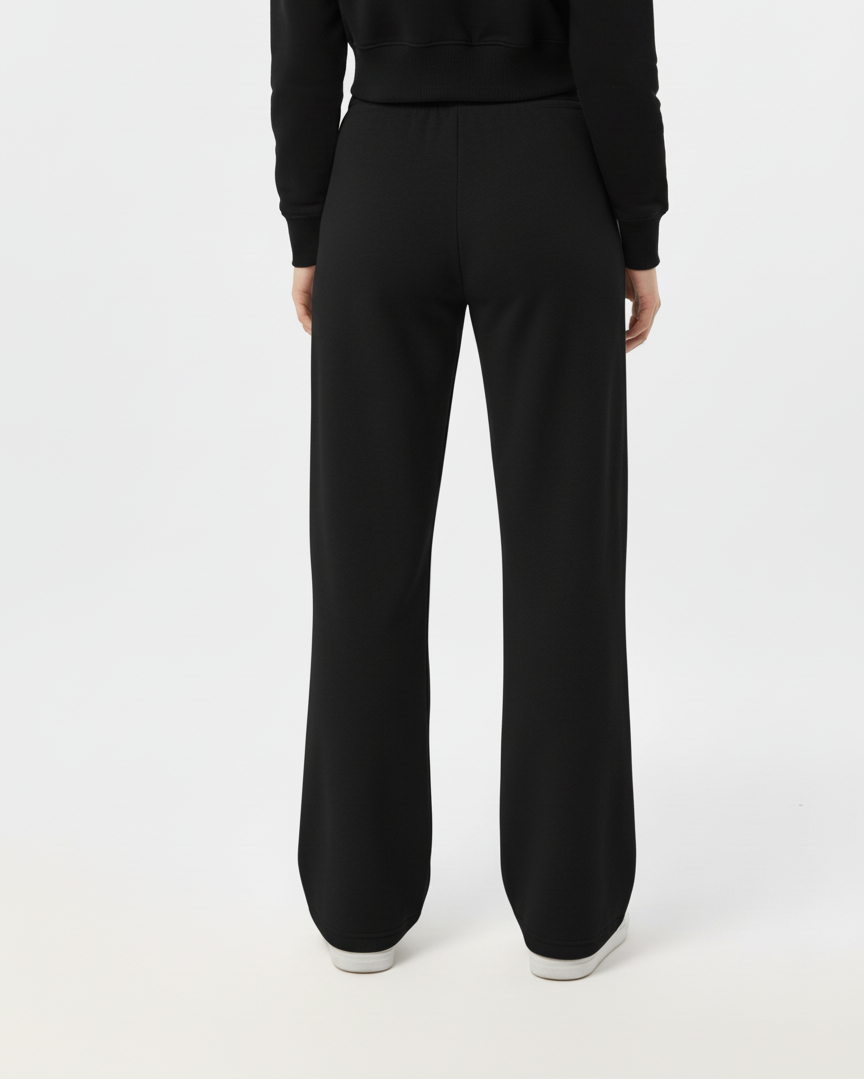 Person wearing a black outfit with wide-leg pants on a white background