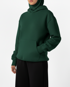 Green hoodie worn by a person on a white background