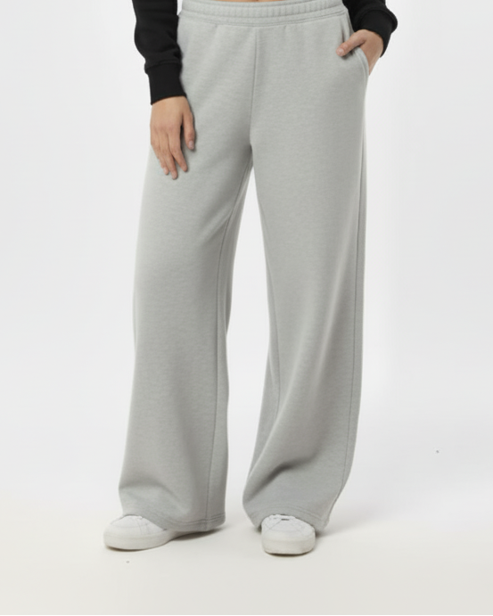 Woman wearing a black sweater and light gray pants on a white background