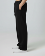 Person wearing black pants on a plain background